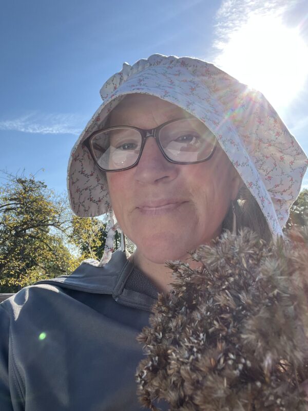 Joe Pye (Eutrochium purpureum) seedhead bouquet and a happy, smiling woman in autumn.